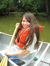 child canoeing at summer camp